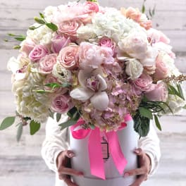 Large pastel bouquet in a white hat box with a pink ribbon