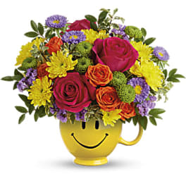Colorful bouquet in a yellow smiley-face mug