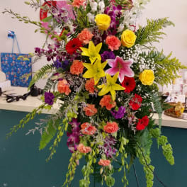 Tall mixed flower standing spray with lilies, roses, and orchids