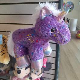 Purple unicorn plush toy with glitter and iridescent accents