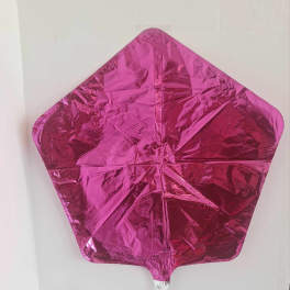 Pink metallic star-shaped balloon against a plain wall