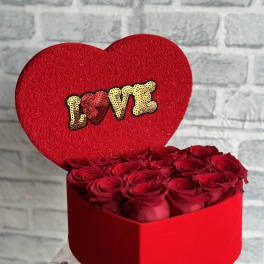 Heart-shaped box of red roses with a red LOVE topper