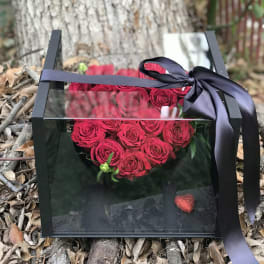 Heart-shaped box of red roses tied with a black ribbon