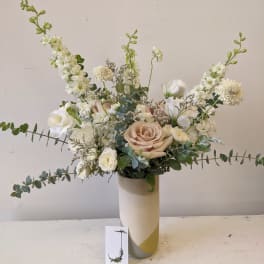 White and blush floral arrangement in a tall vase