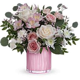 Pink and white rose bouquet in a pink glass vase