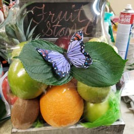 Fruit gift box with apples, orange, kiwi, and a butterfly topper