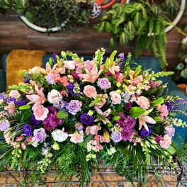 Large pastel floral arrangement with lilies, roses, and carnations