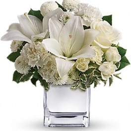 White floral arrangement in a clear square vase