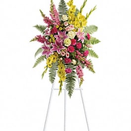 Tall floral spray on a metal easel with pink, yellow, and white flowers