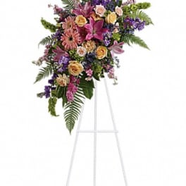 Standing floral spray with pink, purple, and peach blooms on an easel