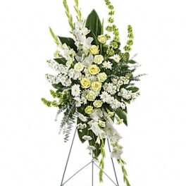 Standing floral spray of white and pale yellow flowers on an easel