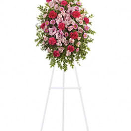 Standing floral spray of pink and red flowers on a white easel