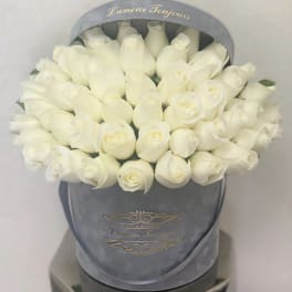 Round box of tightly packed white roses in a gray hatbox printed with L'amour Toujours