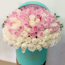 Pink and white roses arranged in a turquoise hat box