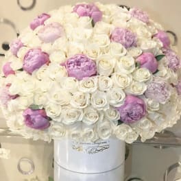 Large bouquet of white and lavender roses in a white vase