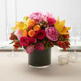 Colorful bouquet of roses and lilies in a dark glass vase