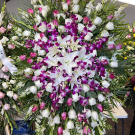 Large standing floral spray with white lilies, pink roses, and purple orchids