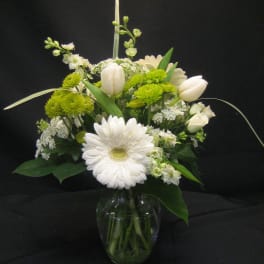 White and green floral arrangement in a glass vase