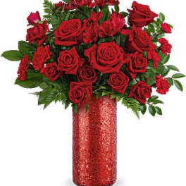 Red roses arranged in a tall glittery vase