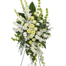 Tall white and pale yellow funeral spray on an easel