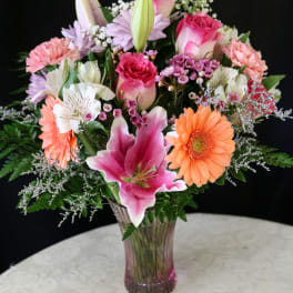 Pink and peach mixed bouquet in a clear glass vase