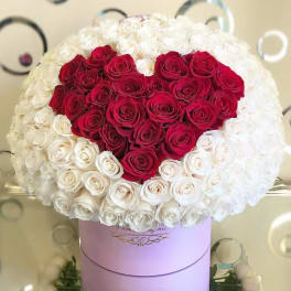 Large heart-shaped red and white rose arrangement in a round hatbox