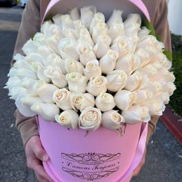 Large cluster of ivory roses arranged in a pink hat box with matching lid