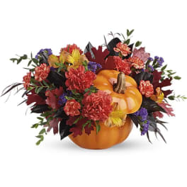 Autumn floral arrangement around stacked pumpkins