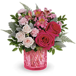 Pink and white rose bouquet in a pink glass vase