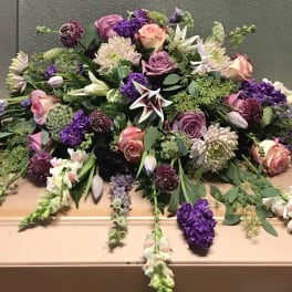 Large casket spray with pink, purple, and white flowers