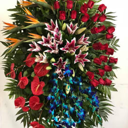 Large standing floral spray with red roses, lilies, and orchids