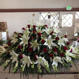 Large floral spray with white lilies and red roses on a table