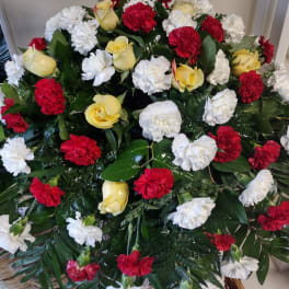 Casket spray with red, white, and yellow flowers