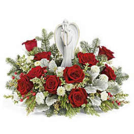 Red roses arranged around a white angel figurine