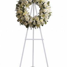 White floral wreath on a metal easel stand