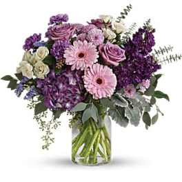 Purple and pink bouquet in a clear glass vase