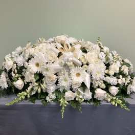 White floral casket spray with roses and daisies