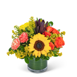 Sunflower and orange rose bouquet in a glass vase
