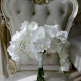 White orchid bouquet resting on an ornate chair