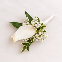 White calla lily boutonniere with small white filler flowers wrapped in white ribbon