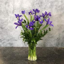 Purple iris bouquet in a clear glass vase