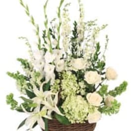 White floral arrangement in a wicker basket with tall stems
