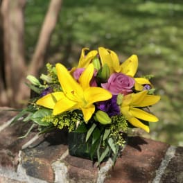 Yellow lilies and pink roses in a glass vase