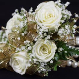 White rose bouquet with baby's breath and gold ribbon on a pearl bracelet
