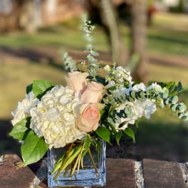 Blush roses and white hydrangeas in a clear glass vase