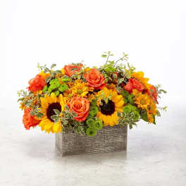 Orange roses and yellow sunflowers in a rectangular wooden container