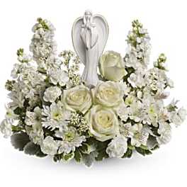 White floral arrangement with a praying angel figurine