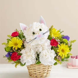 Cat-shaped flower arrangement in a wicker basket with bright daisies and carnations