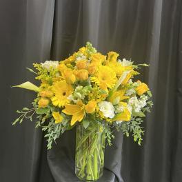 Yellow floral arrangement in a clear glass vase
