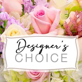 Pastel arrangement of pink roses, white hydrangeas, and lavender flowers with a Designer's Choice card.